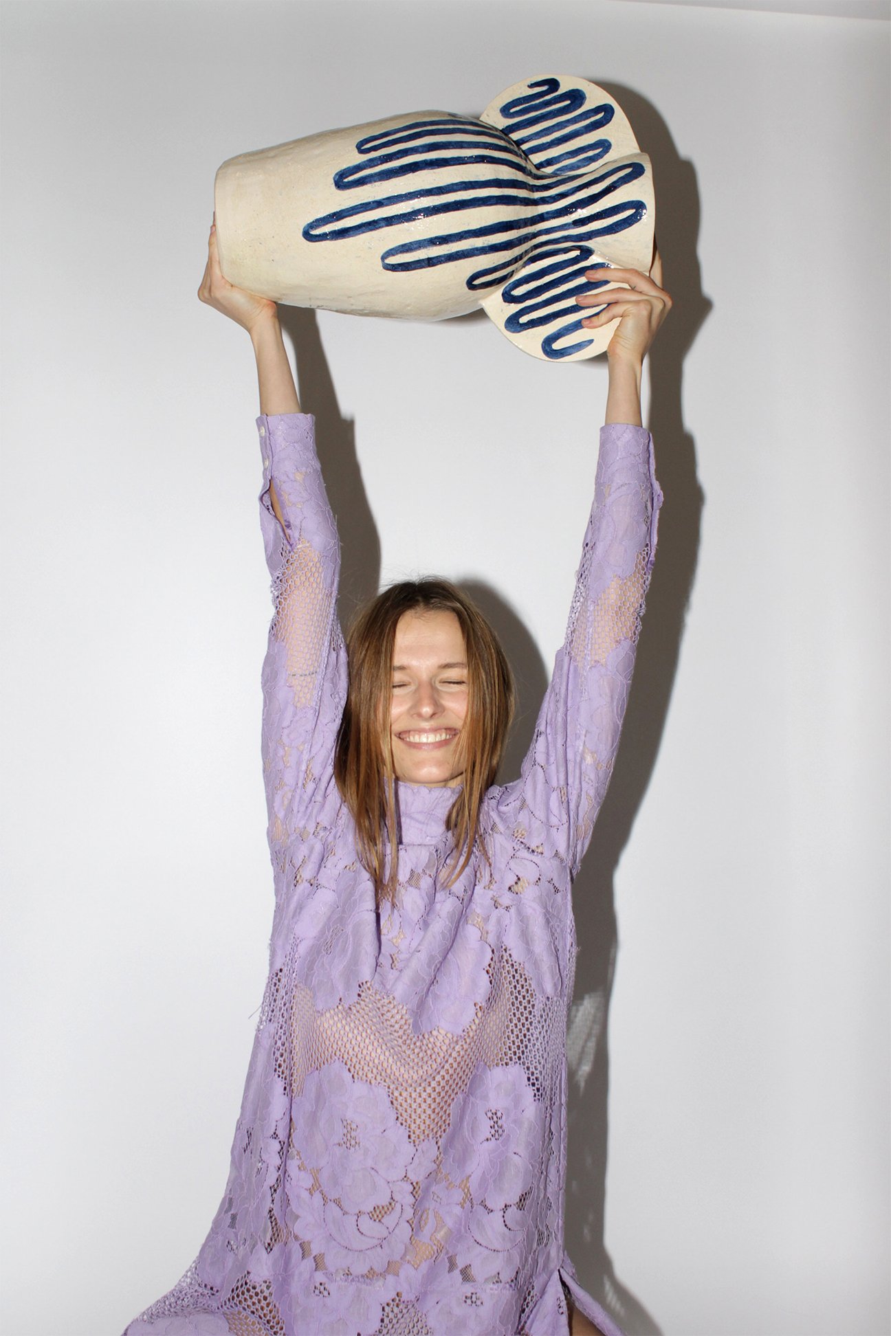 person in purple dress holding vase