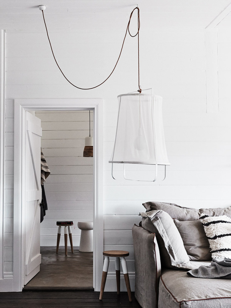 large white fabric pendant light next to a gray sofa