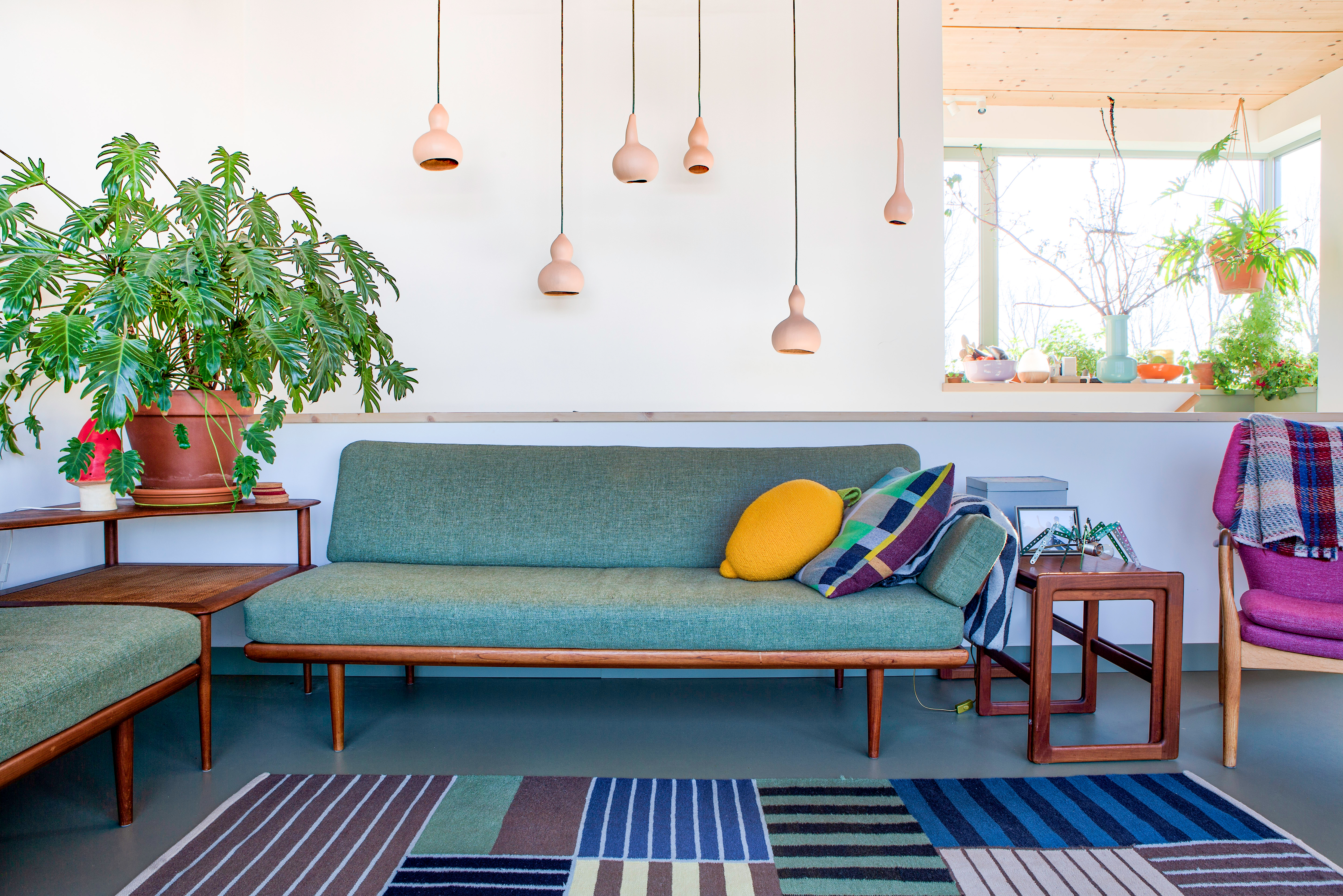 Living room with green sofa and striped blue rug