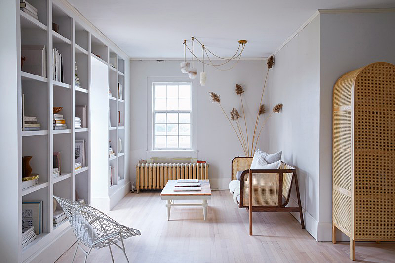 Small living room with cane sofa and bookcase