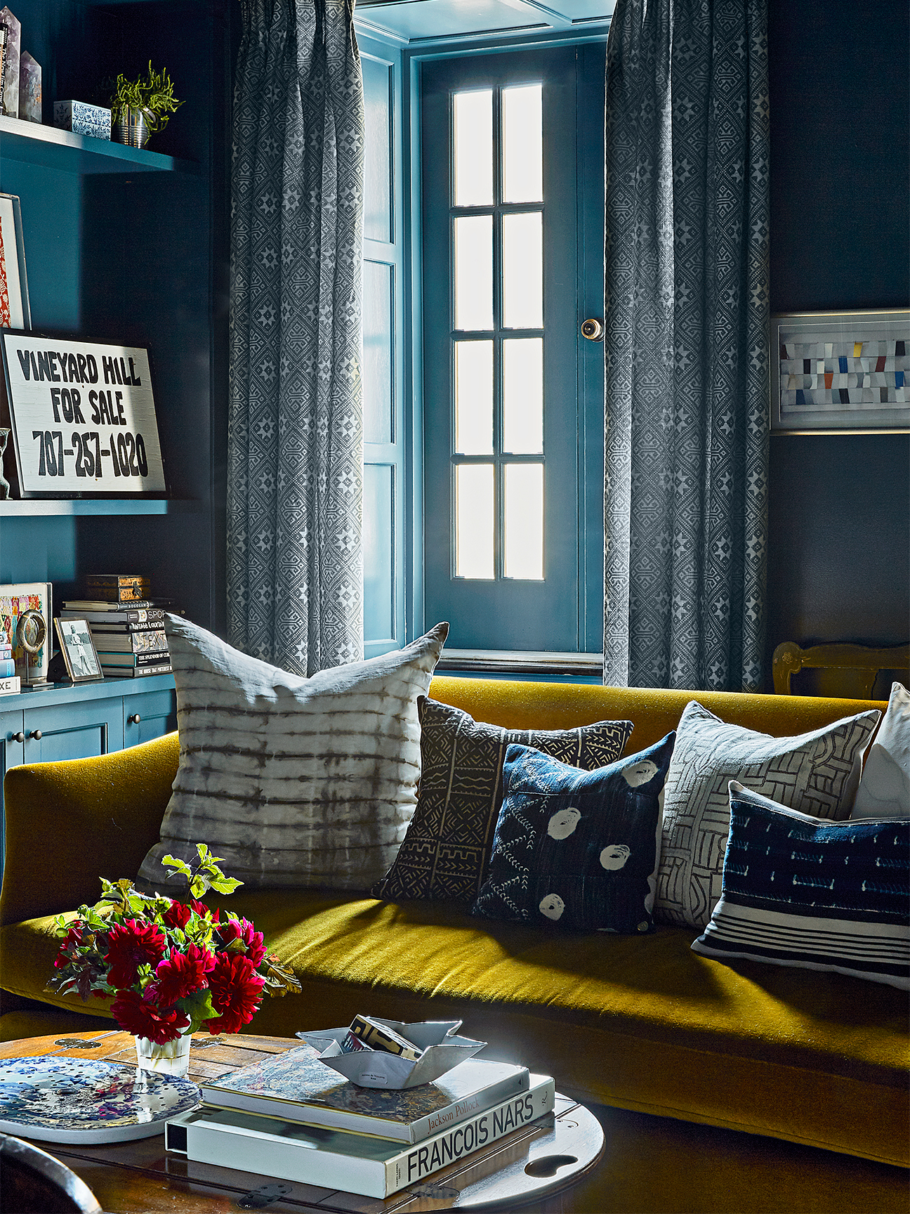 Small living room with navy walls and citrine sofa