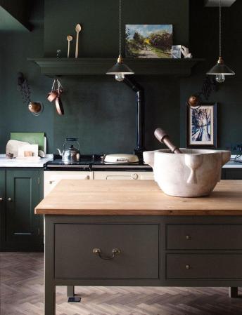green kitchen with island that has a mortar and pestle on it