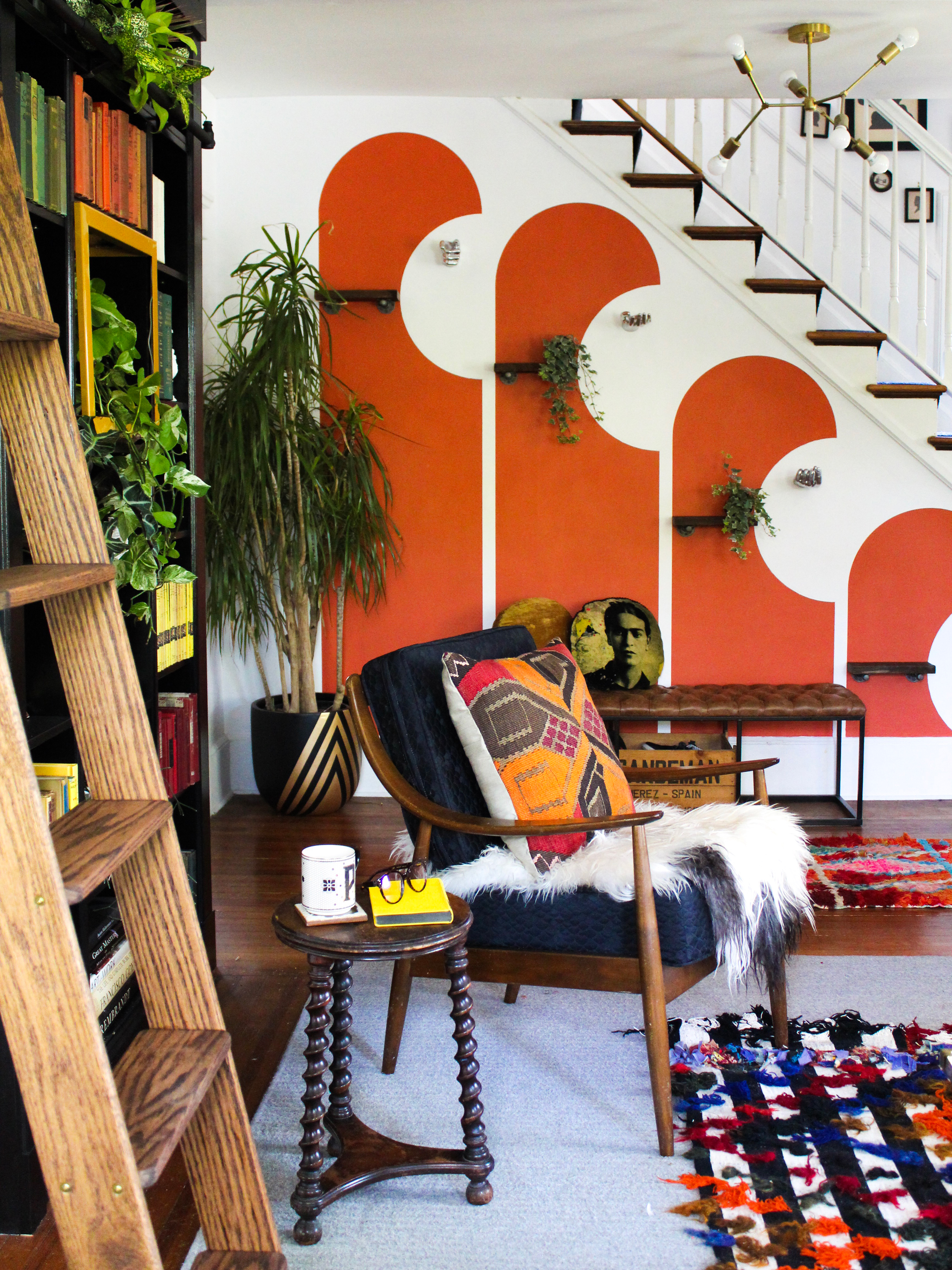 living room with red shapes painted on the staricase wall