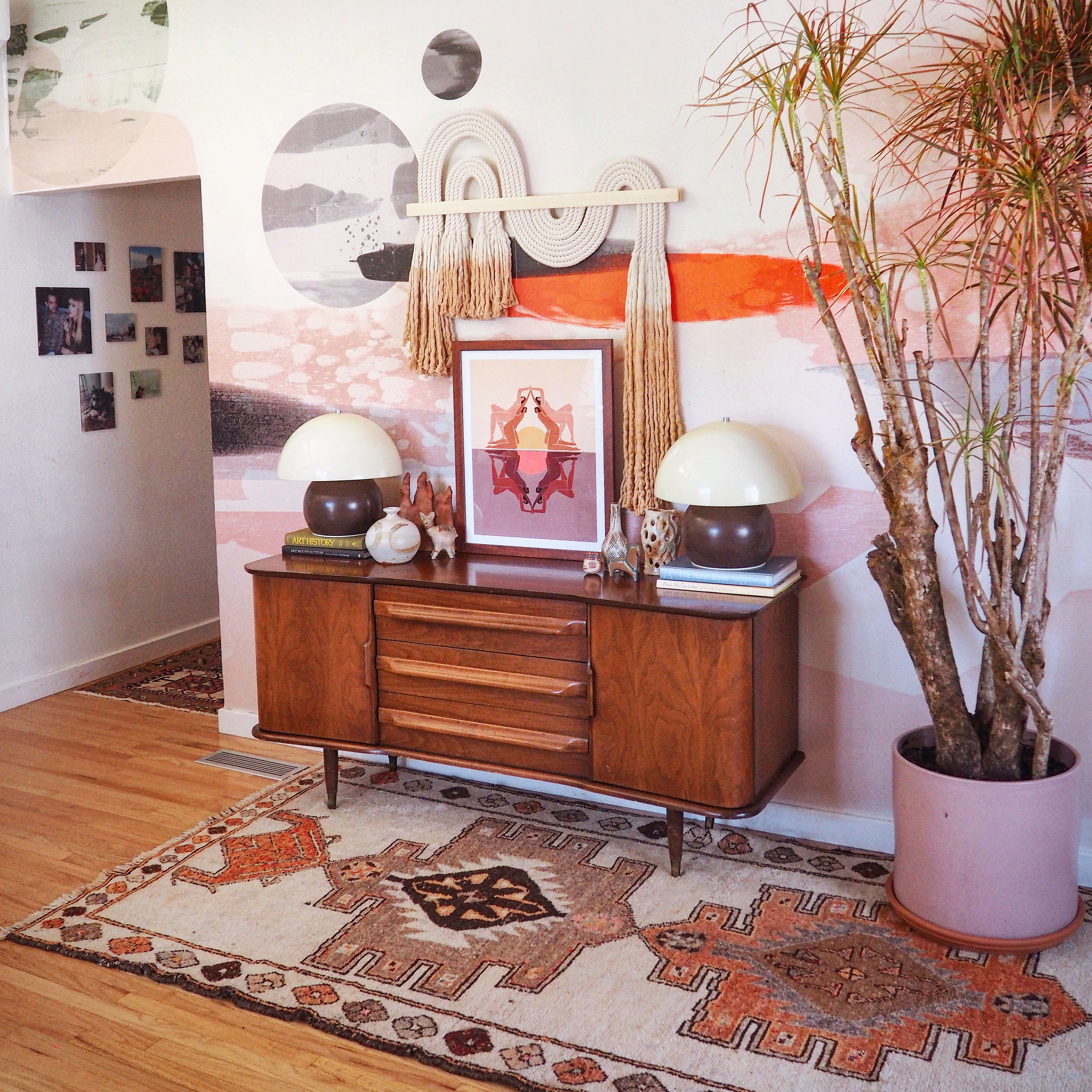 pink mural in a hallway with a mid century chest