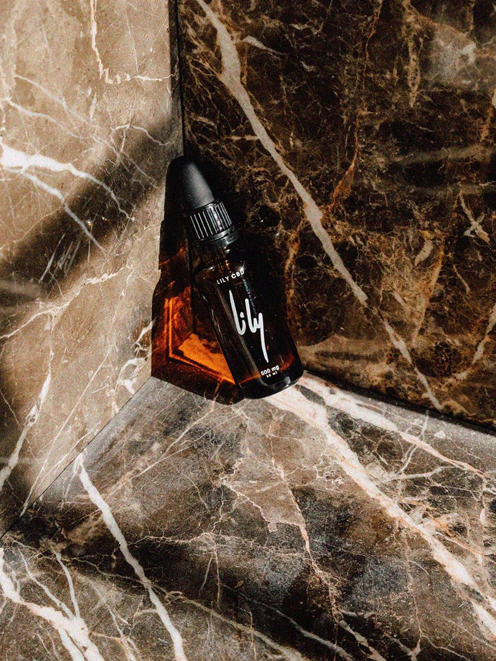 Vial of CBD oil against marble background