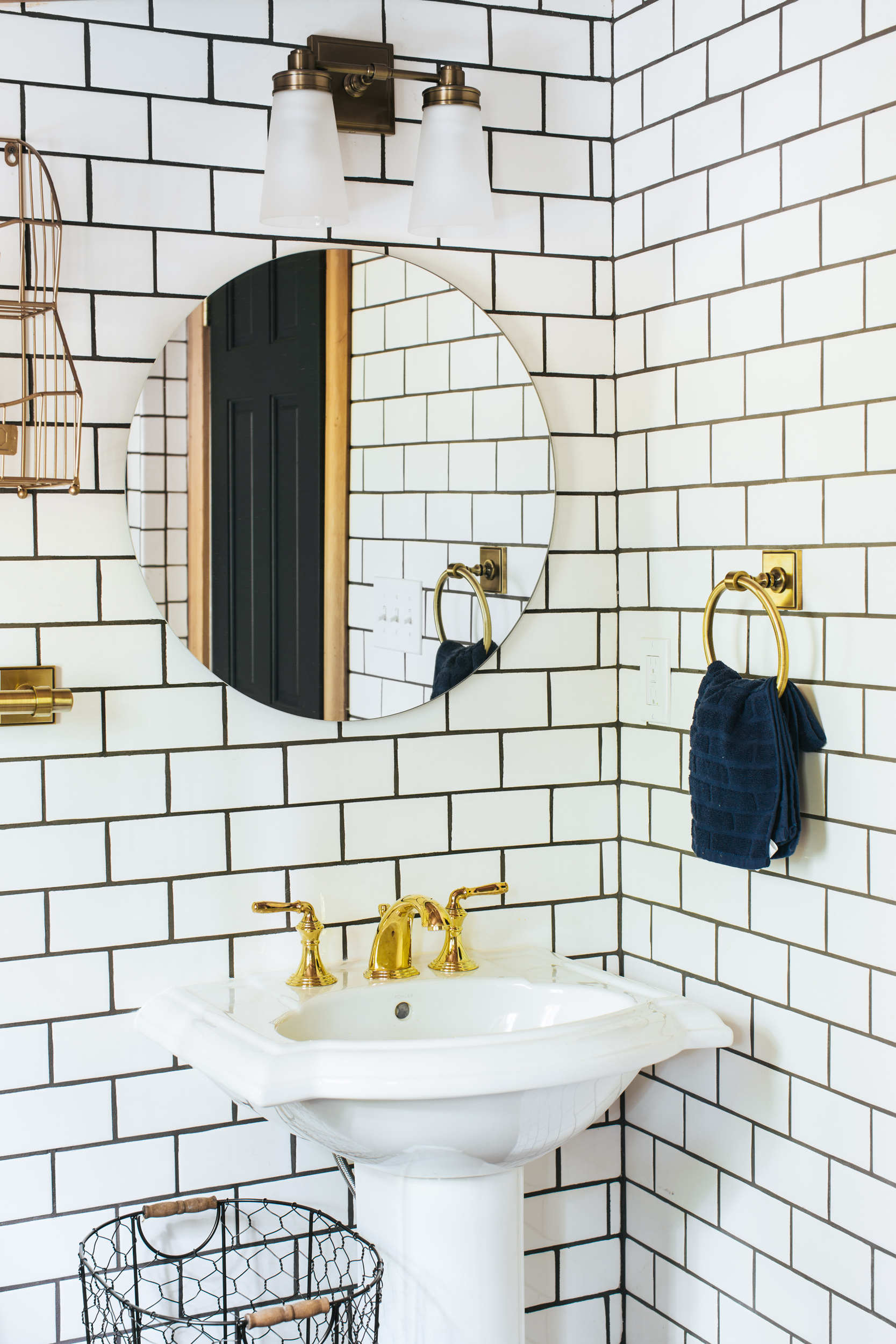 subway tile bathroom with round mirror