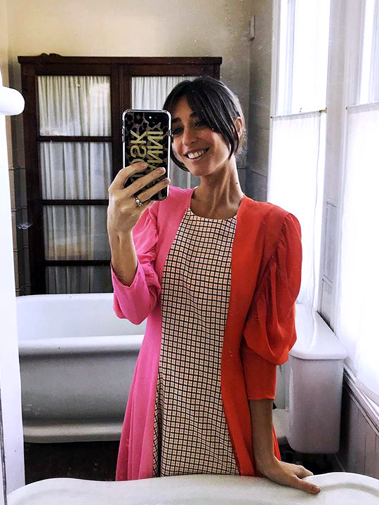woman in red and pink dress taking mirror selfie