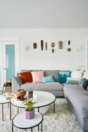 white living room with grey sofa and colorful throw pillows