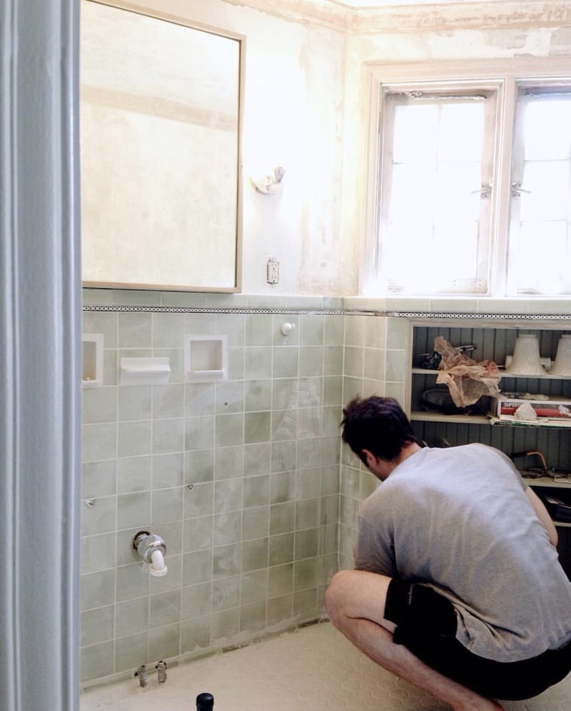 man working on a tiled wall