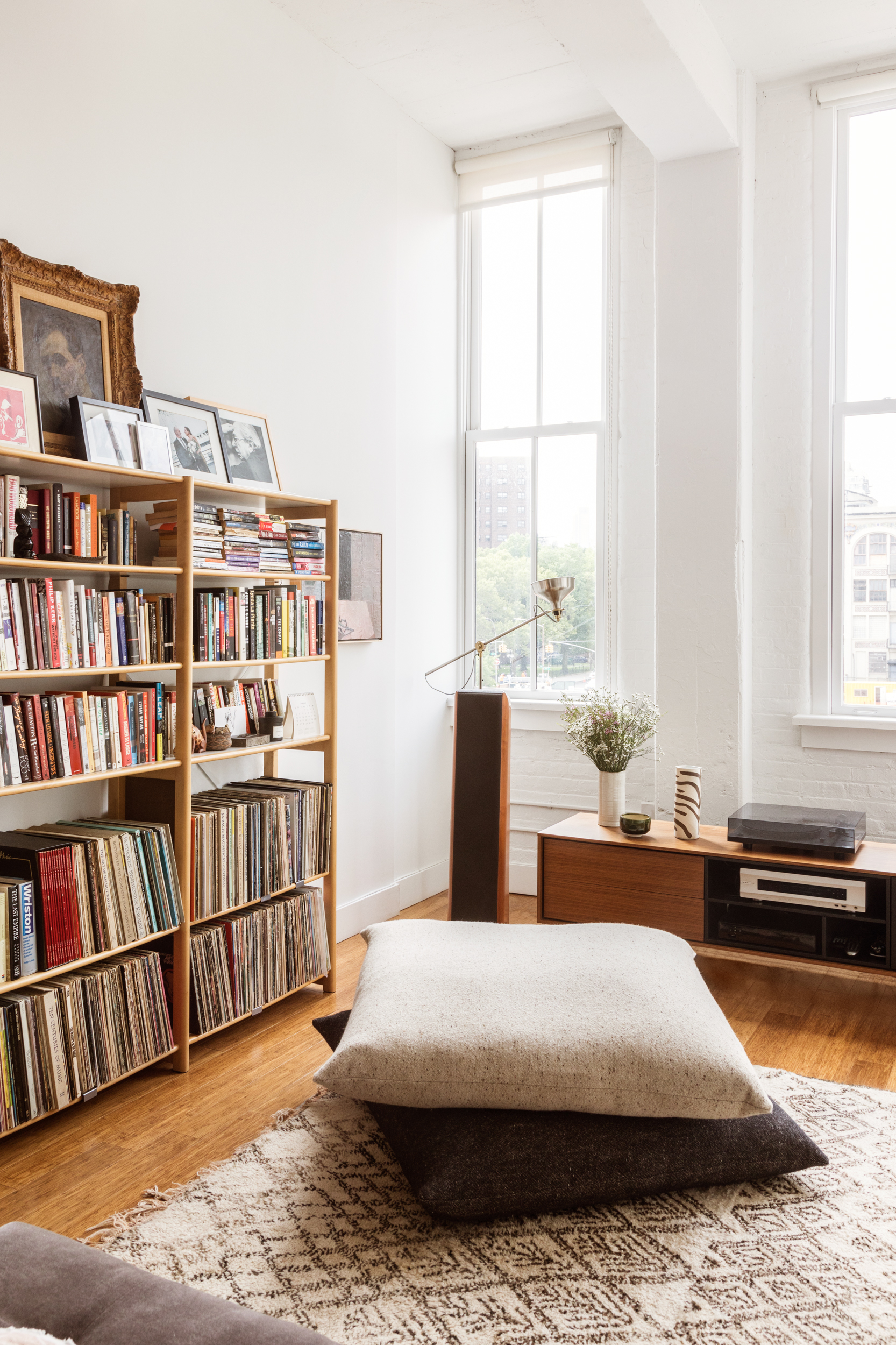 living room with bookcases and floor pillows