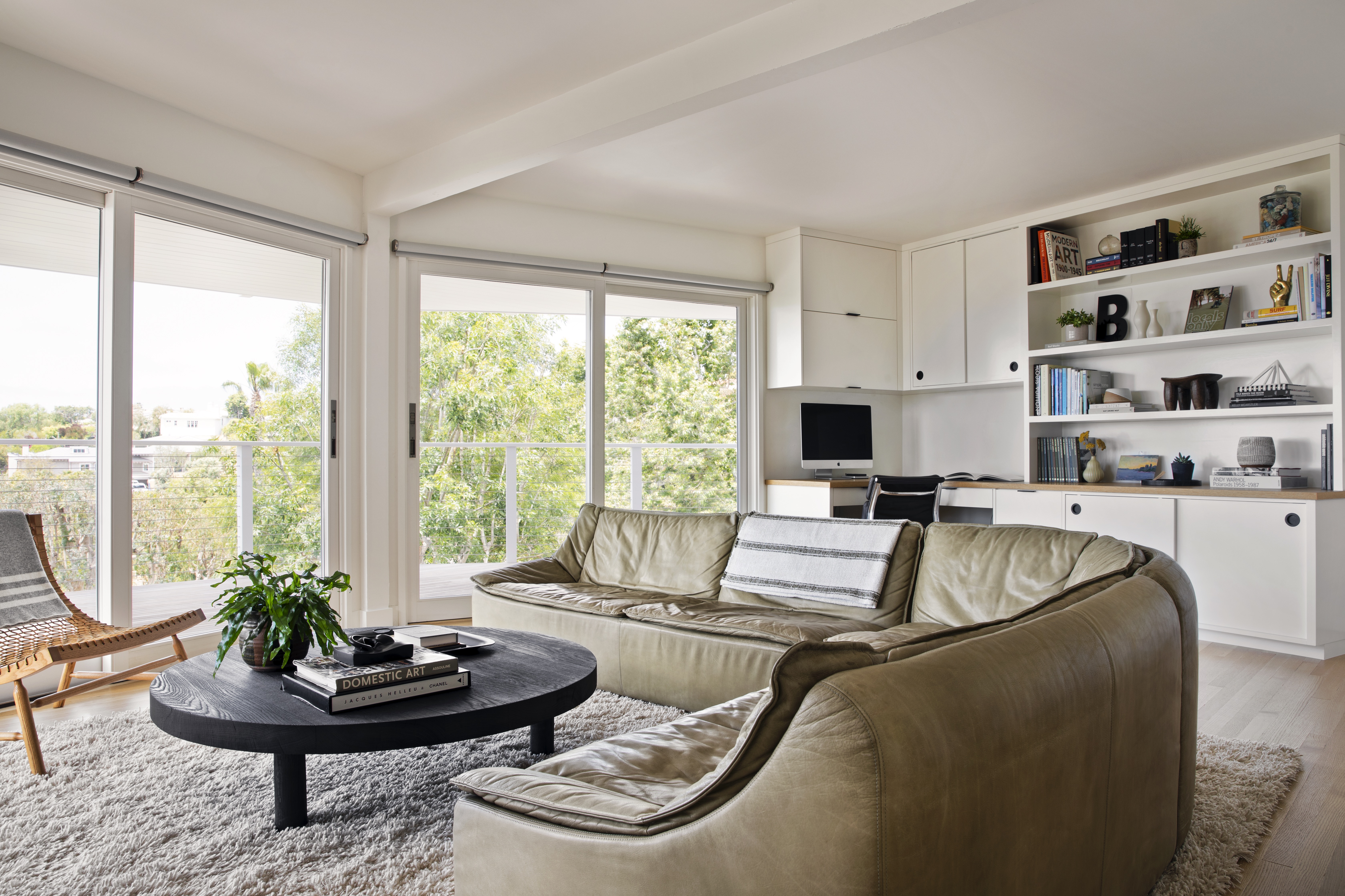 curved olive green sofa in bright mid century room