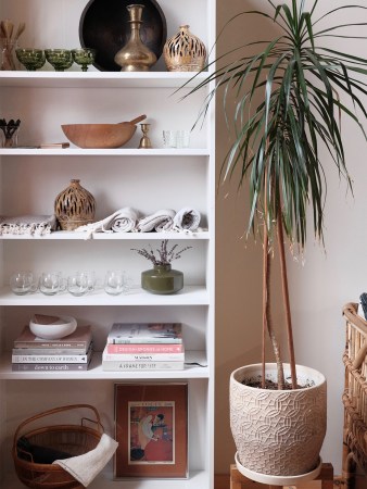 open bookcase stocked with baskets and candles