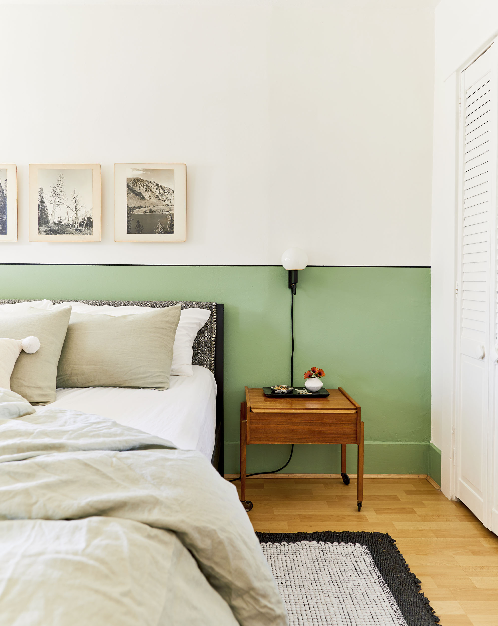 bed sitting against a half-painted green wall