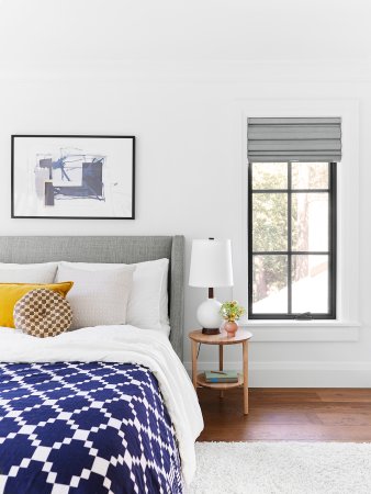 Bedroom with blue quilt and white walls