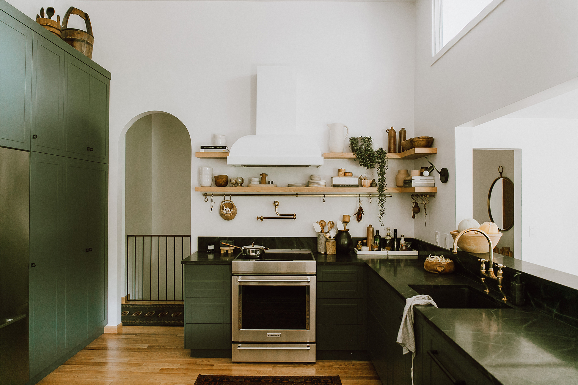 kitchen with an archway door and matte white hood