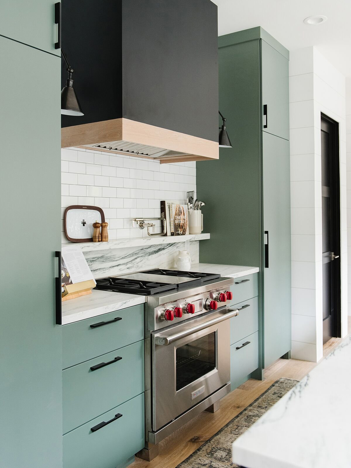 black and brass range and marble backsplash