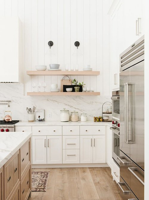 large white kitchen with steel fridge and wood island