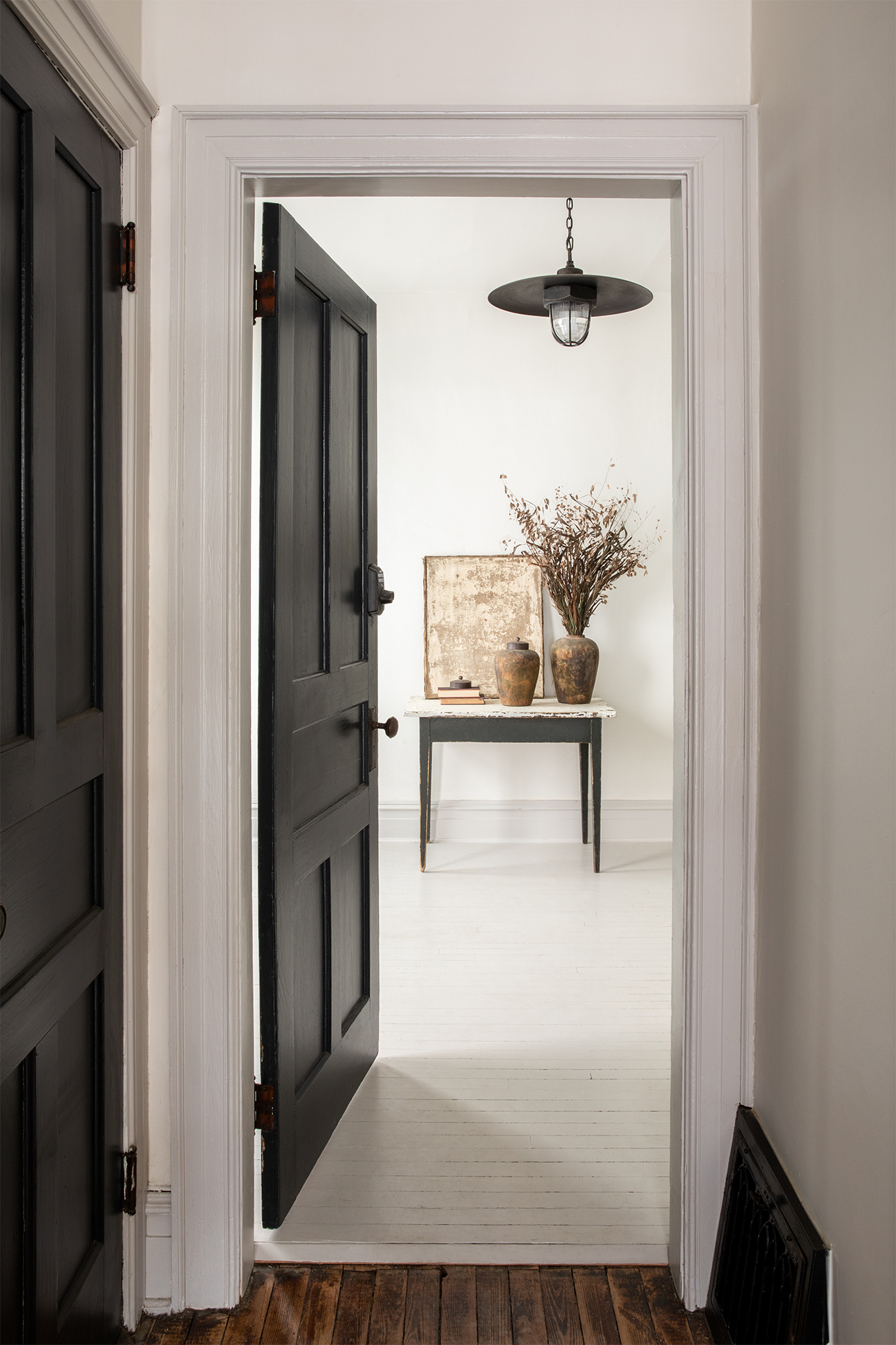 white hallway with black door