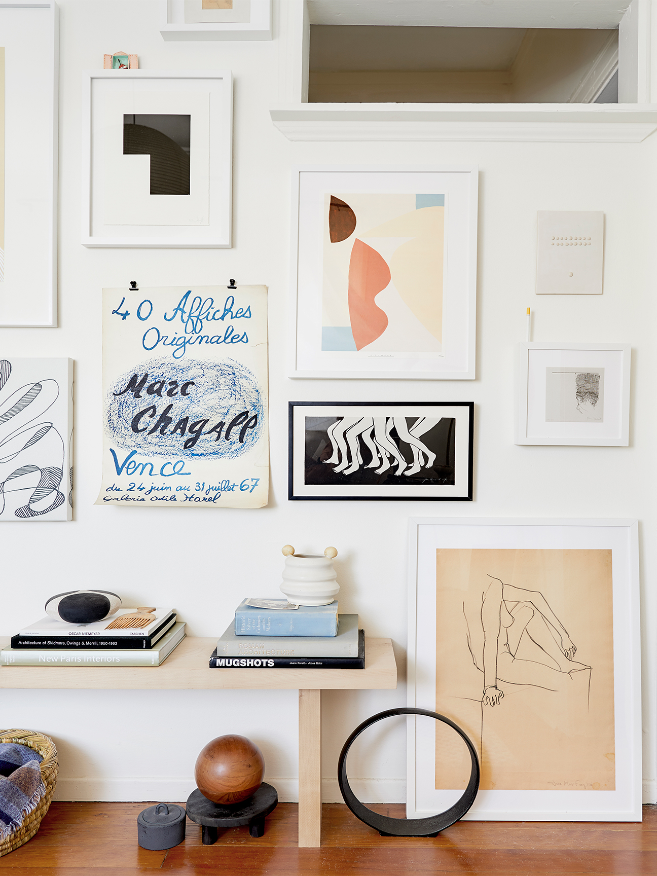 gallery wall behind a bench with assorted objects