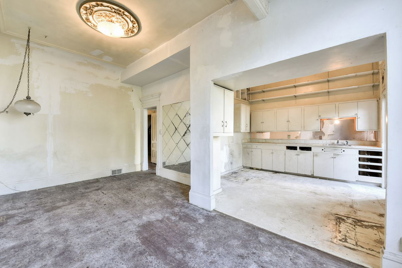 dated white kitchen off a dining room