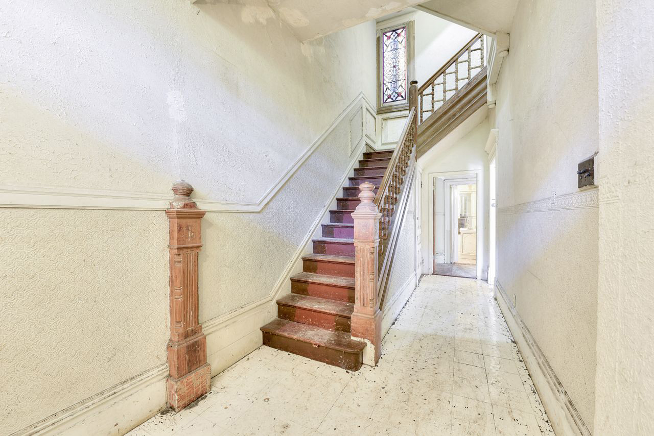 foyer with white walls and wood staircase