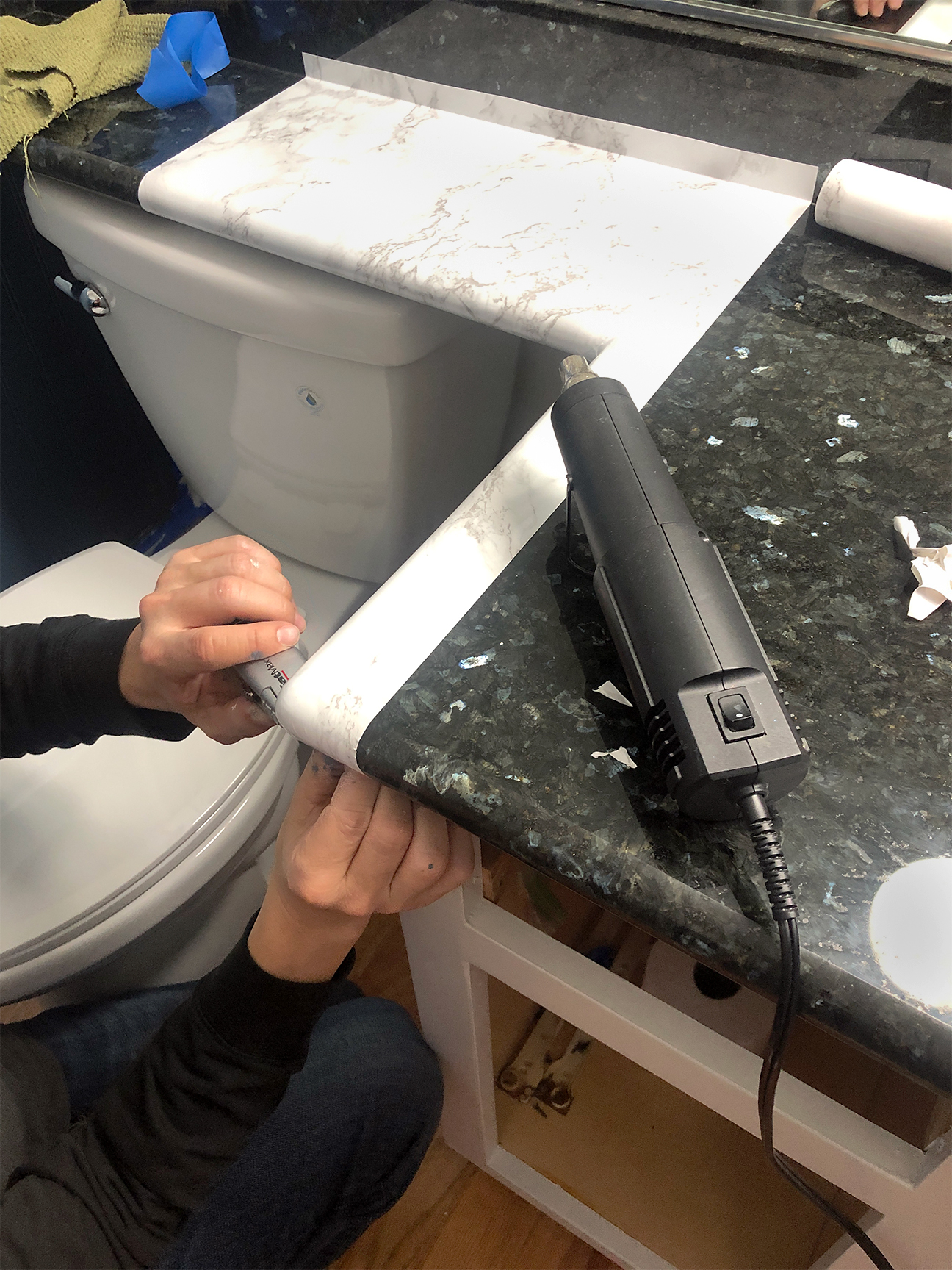 black granite bathroom counter with contact paper over it