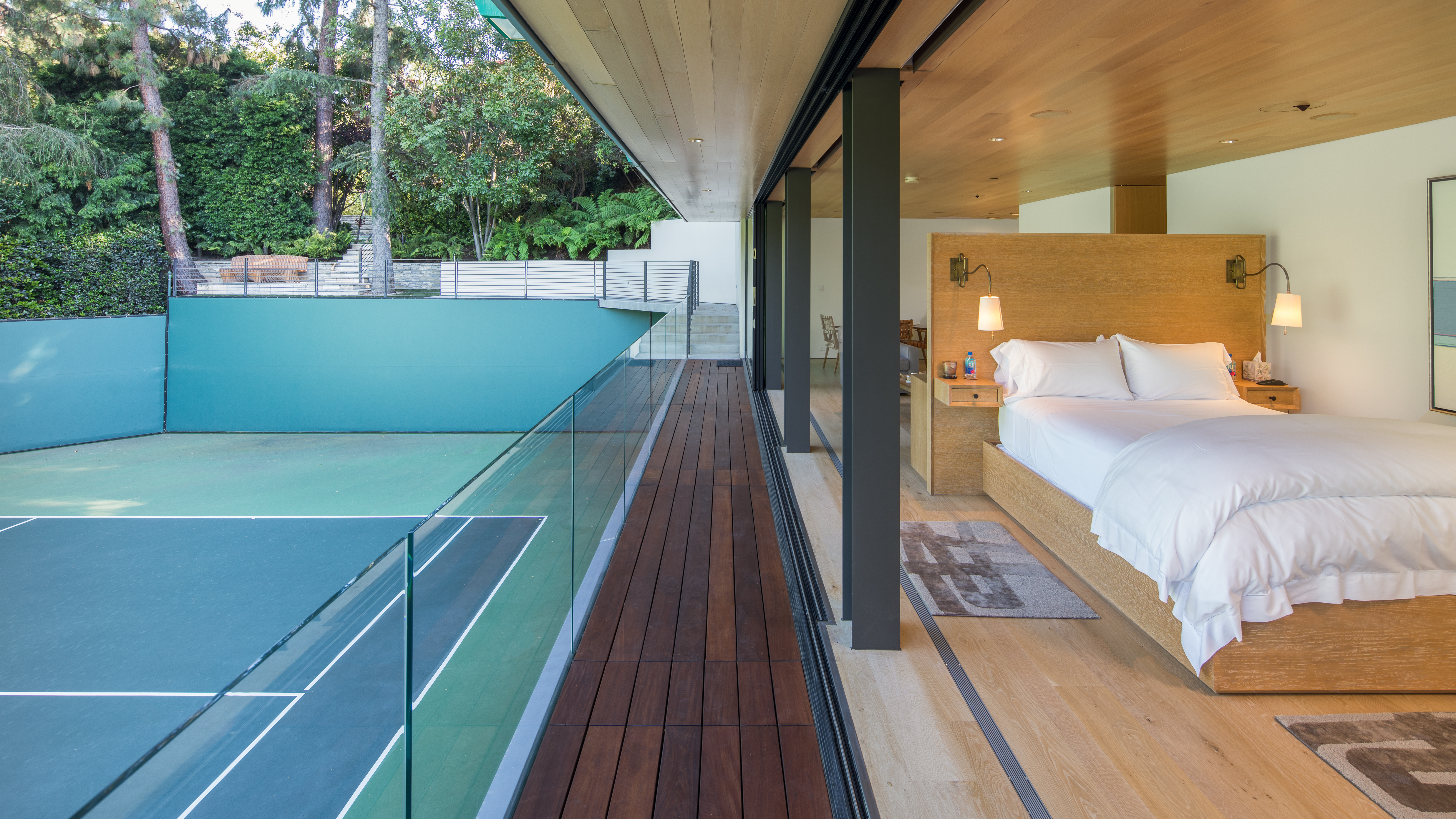 bedroom with open doors overlooking tennis court