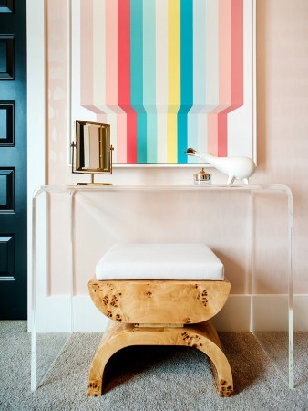 pink room with a vanity and burl wood stool