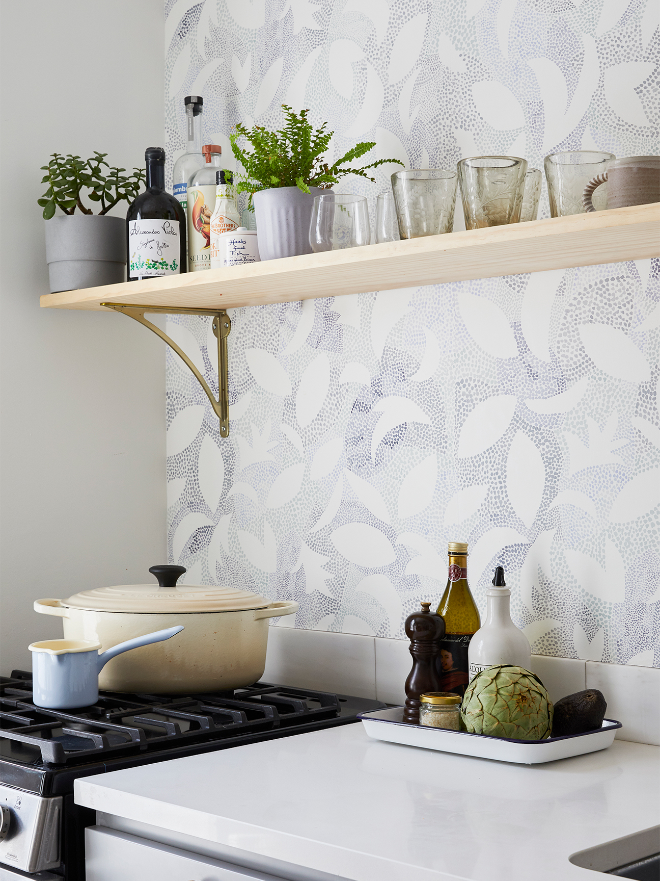 speckled blue wallpaper and stovetop with cookware on it