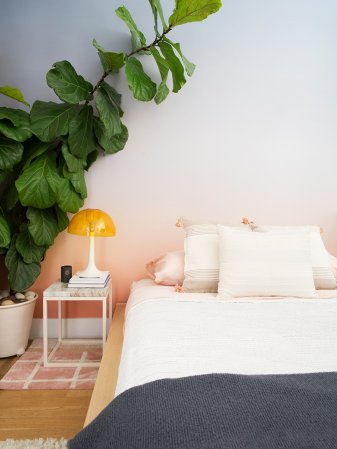 bed with ombre wallpaper behind it