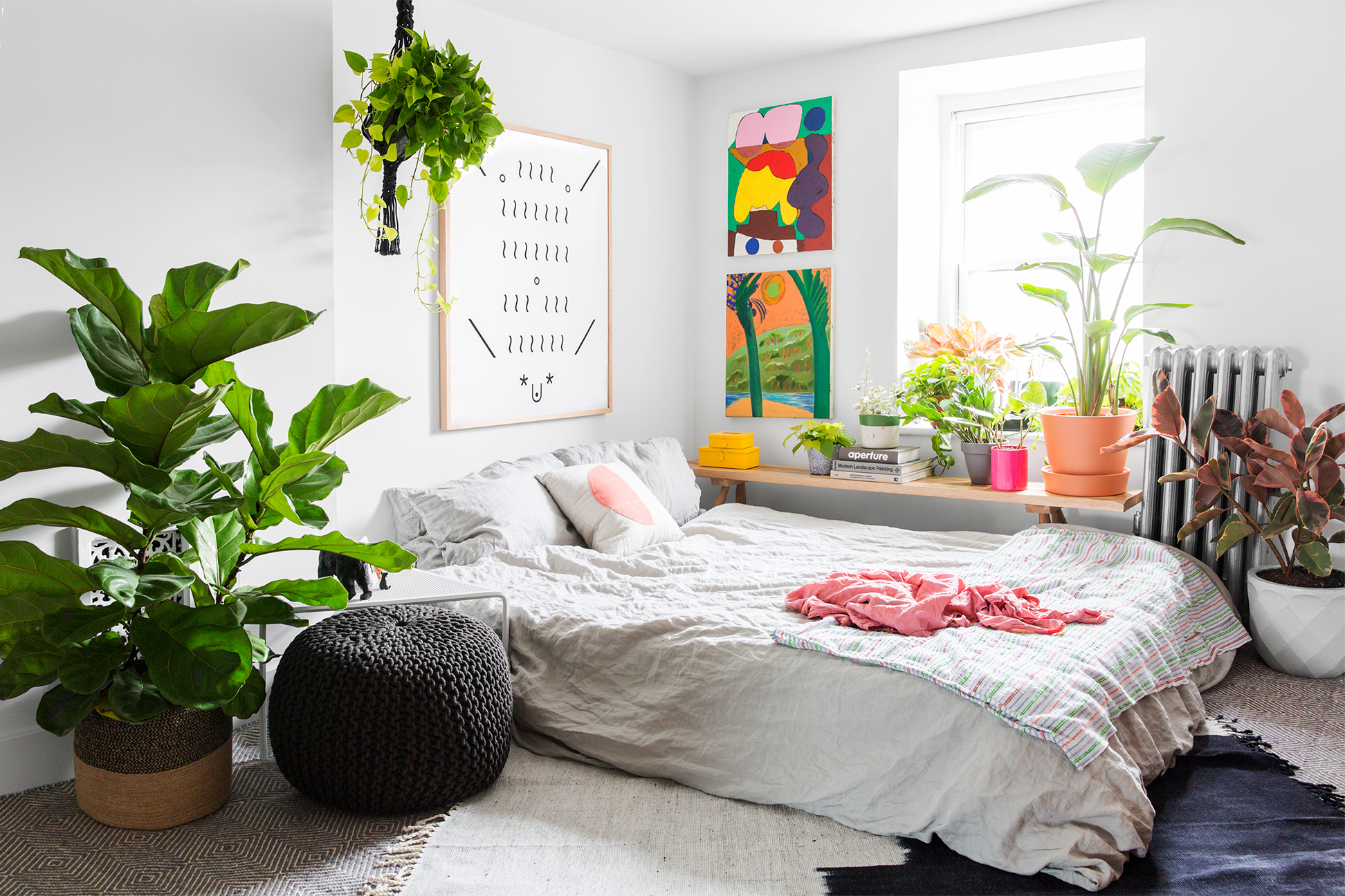 bedroom with lots of plants and rainbow artwork