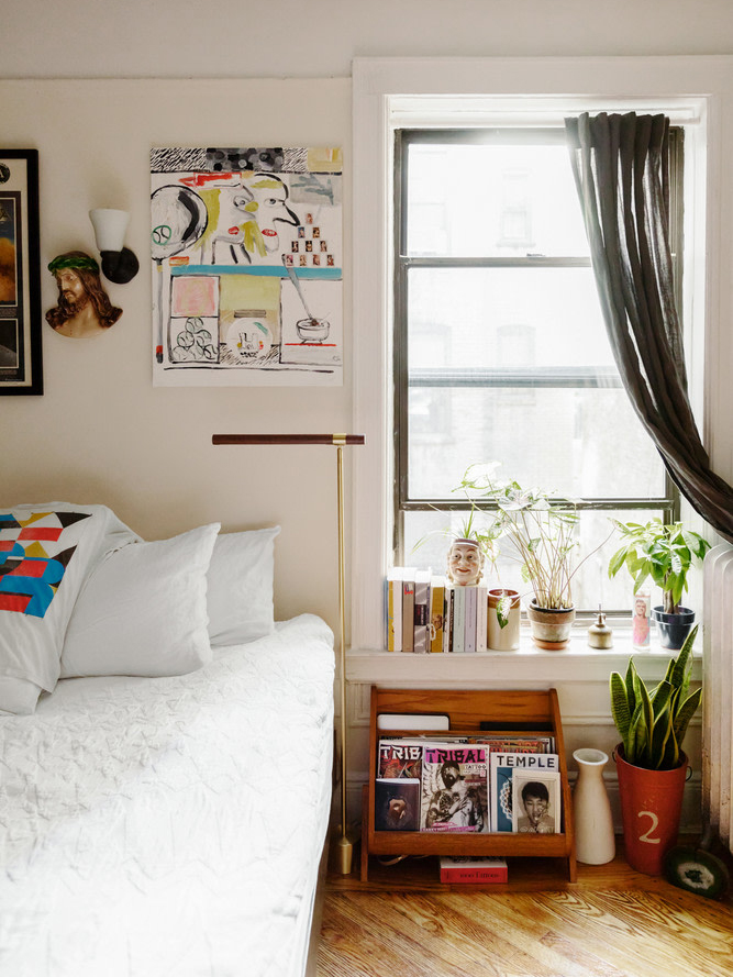 bed with white bedding and books on windowsill