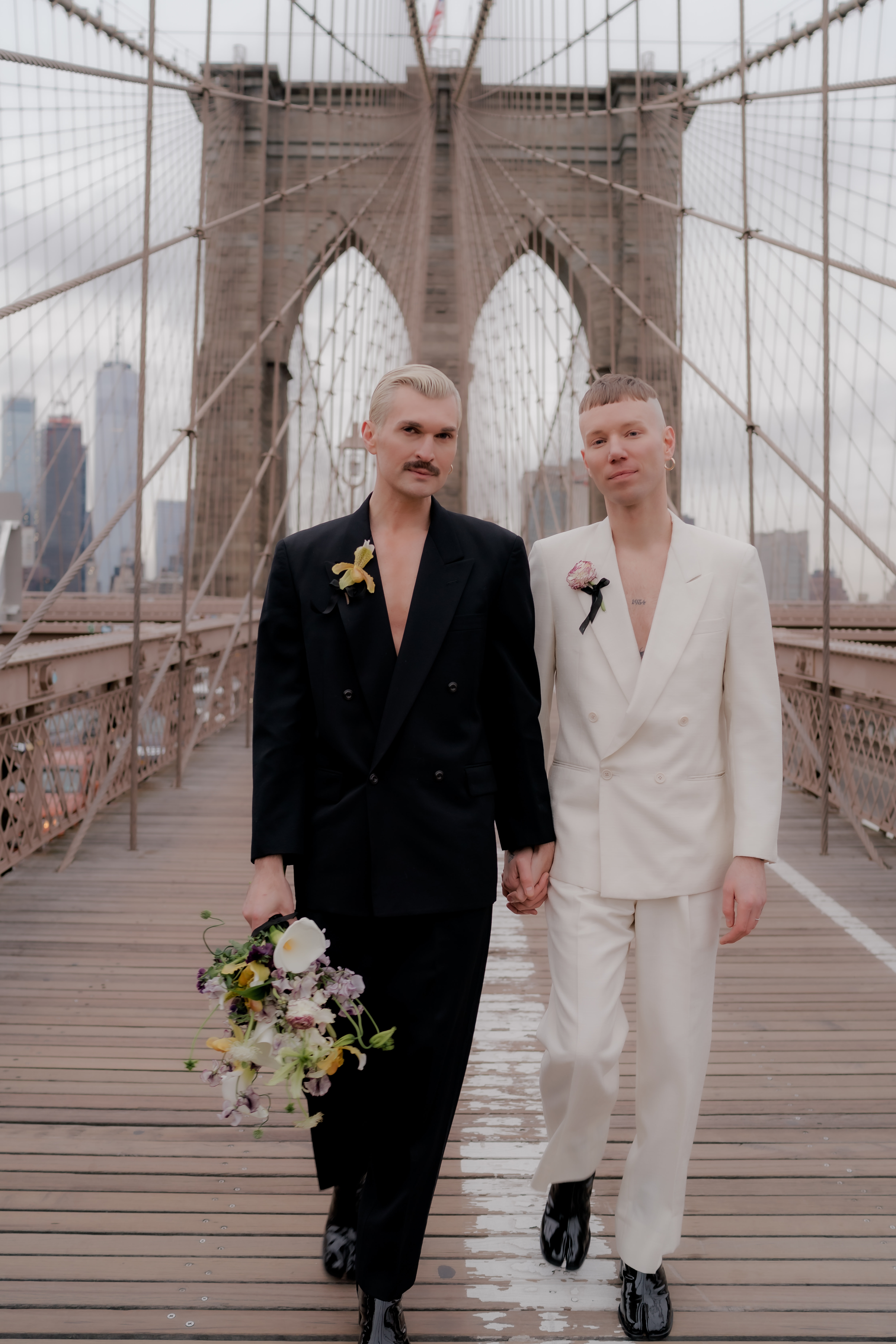 men holding hands on bridge