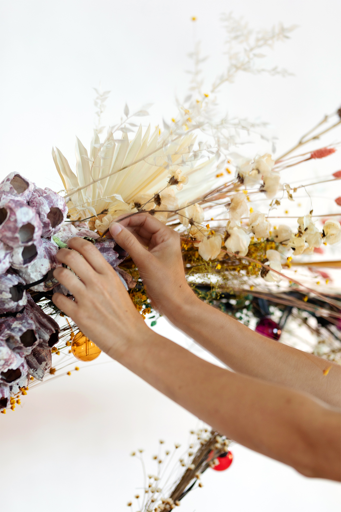 hands putting together floral installation