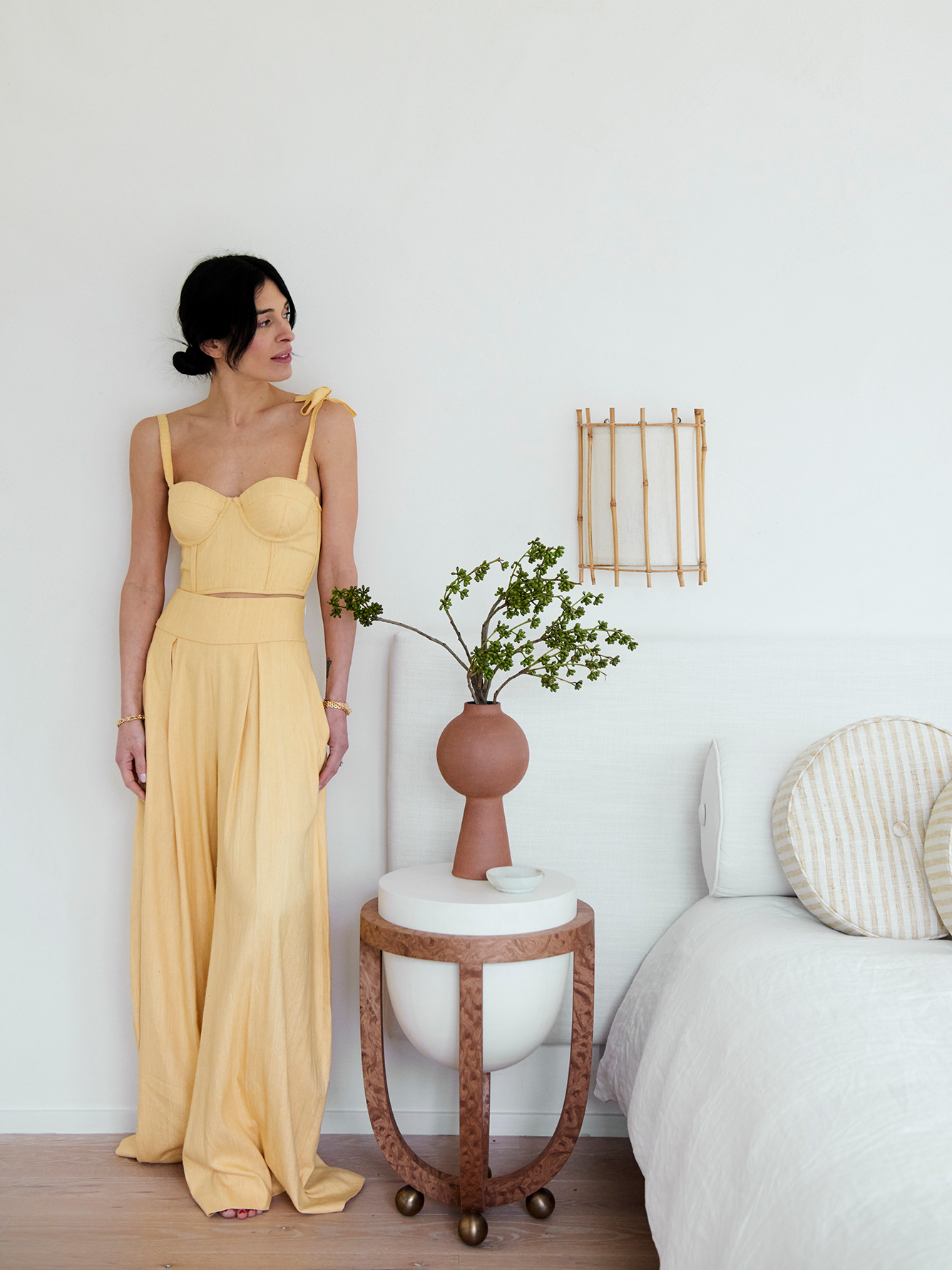 woman in yellow leaning against a wall