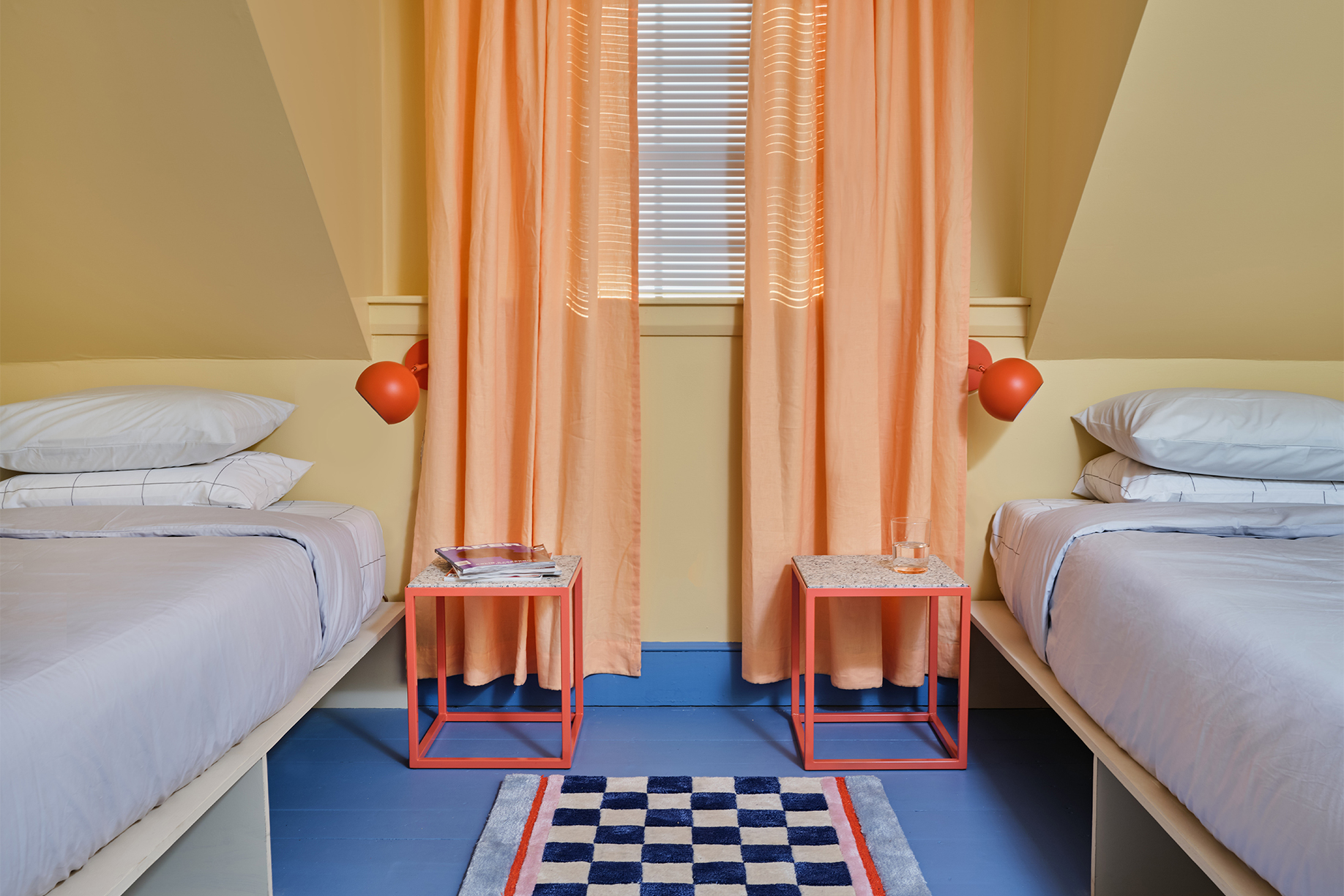 Room with yellow walls and twin blue beds