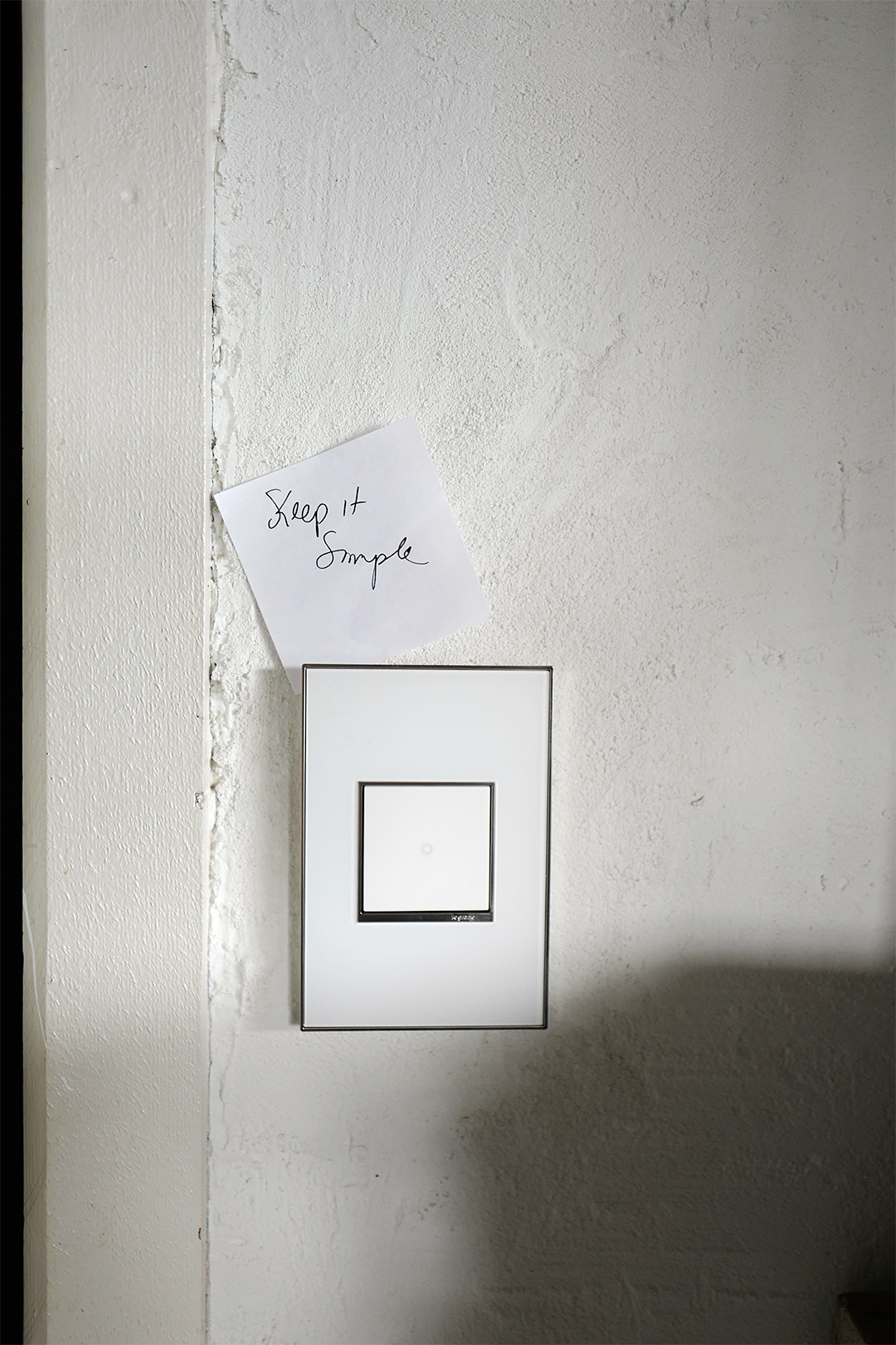 white light switch with note stuck to it