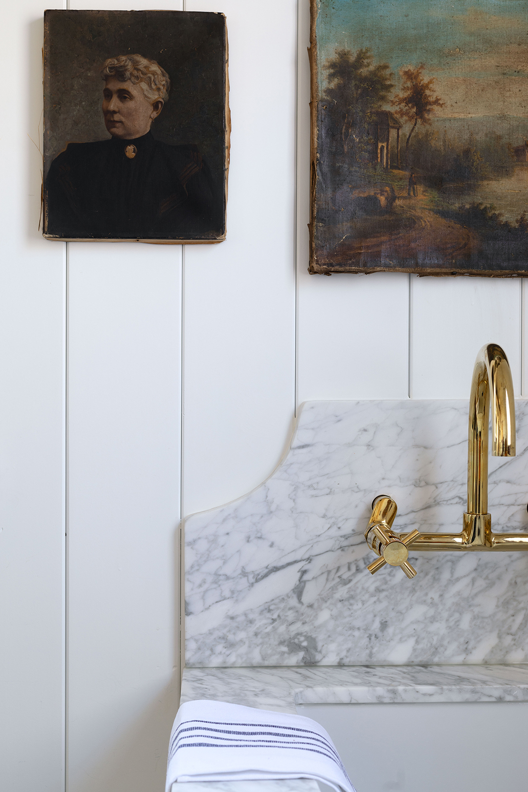 marble curved backsplash with brass faucet