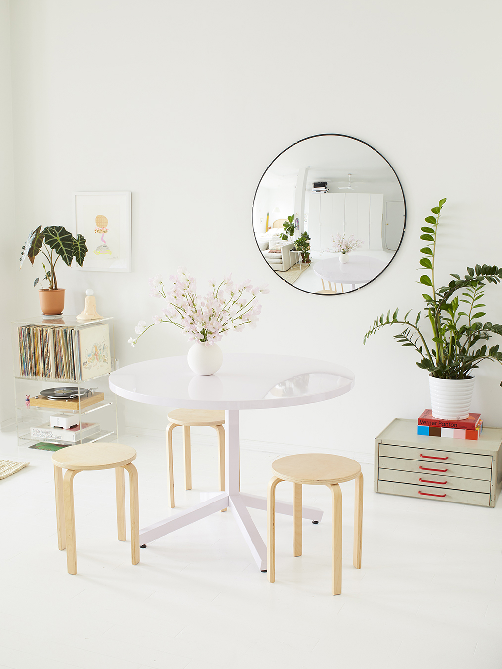 white room with dining table and light wood stools