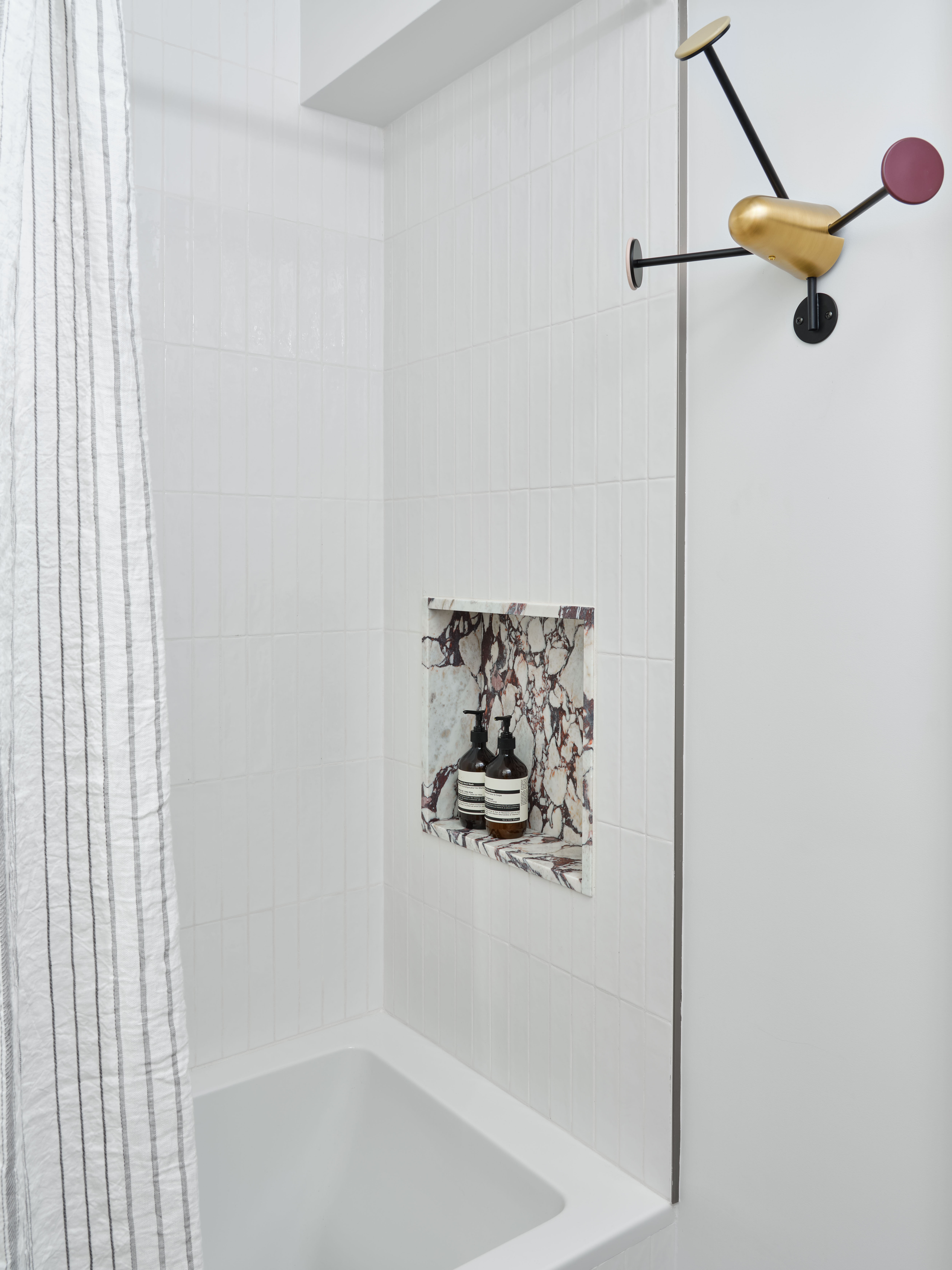 white bathroom with marble shower nook