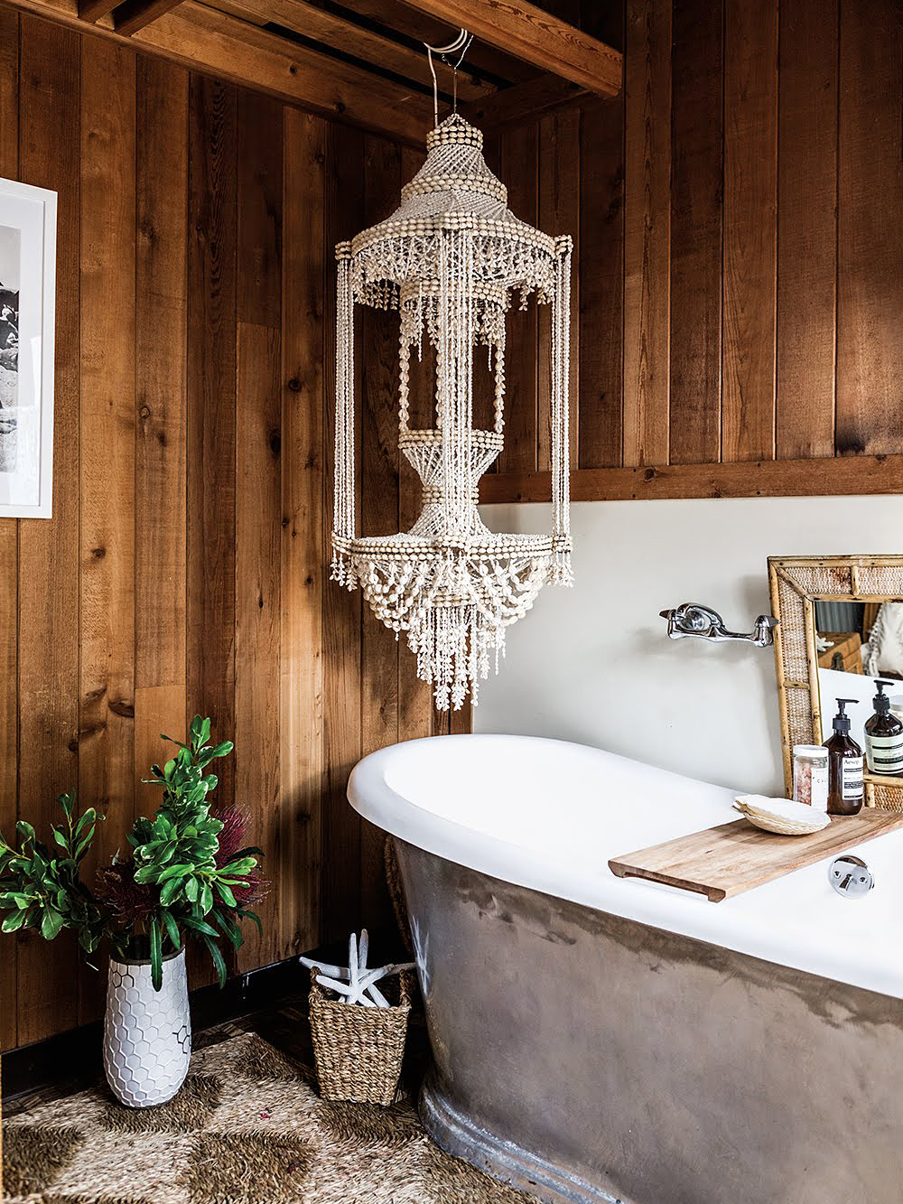 bathtub with elaborate light fixture hanging over it