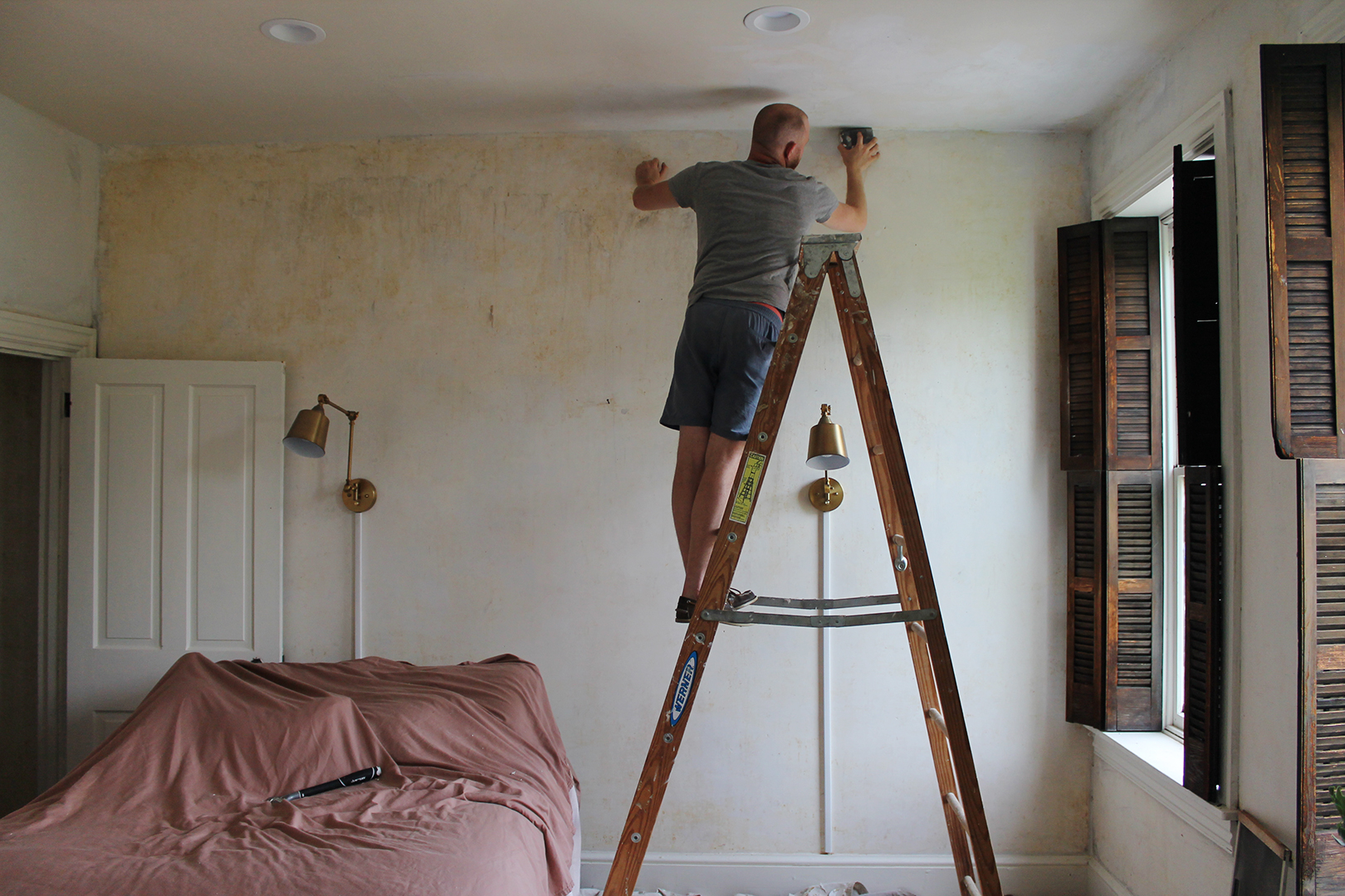 man painting the top of a wall