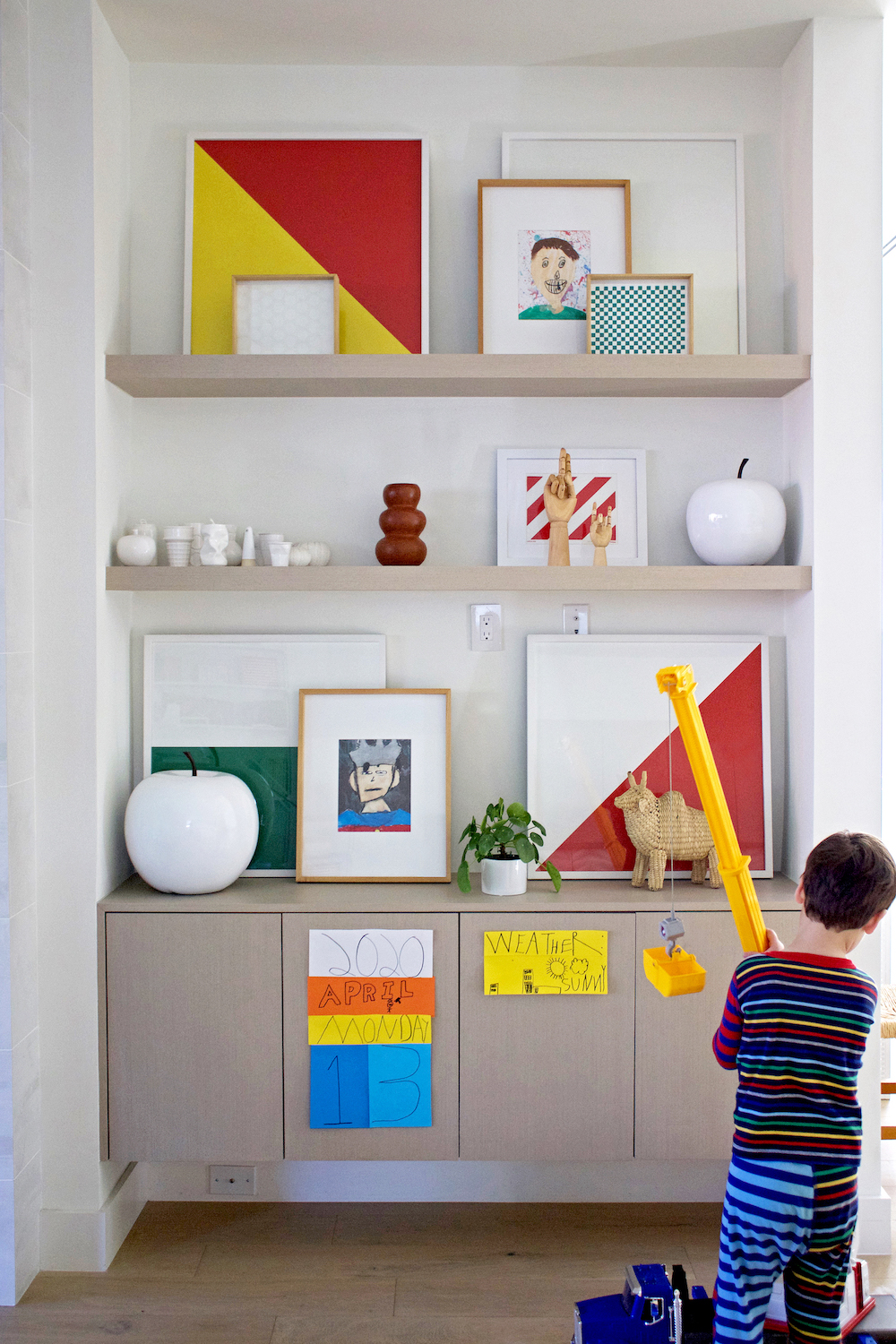 boy playing with toy in front of shelves