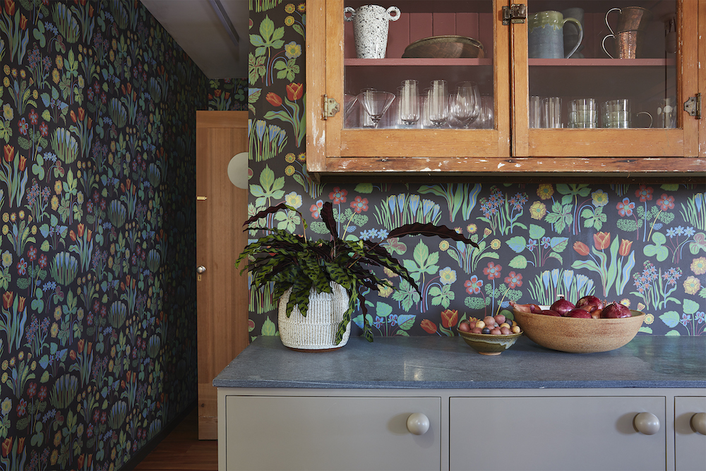 wood and glass cabinets with botanical wallpaper all around