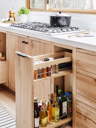 drawer coming out of a cabinet with spices in it