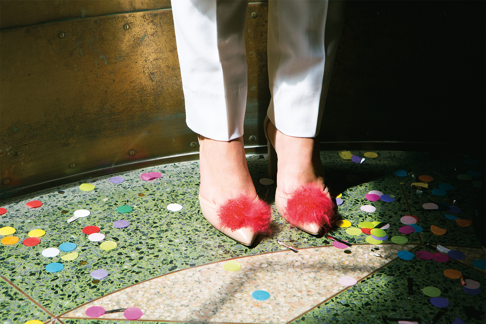 shoes with pom poms and confetti on the floor