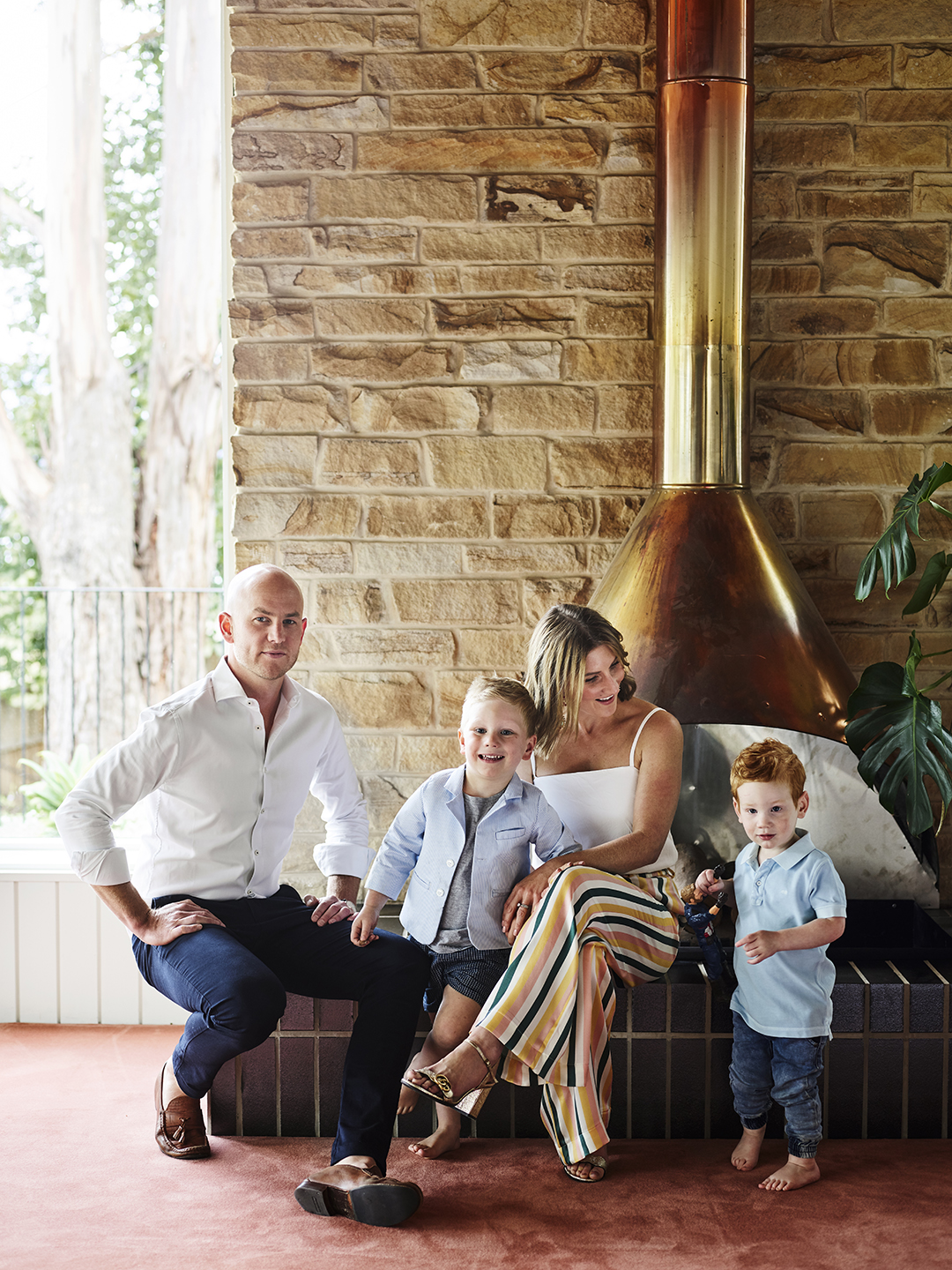 family of 4 in front of copper wood stove