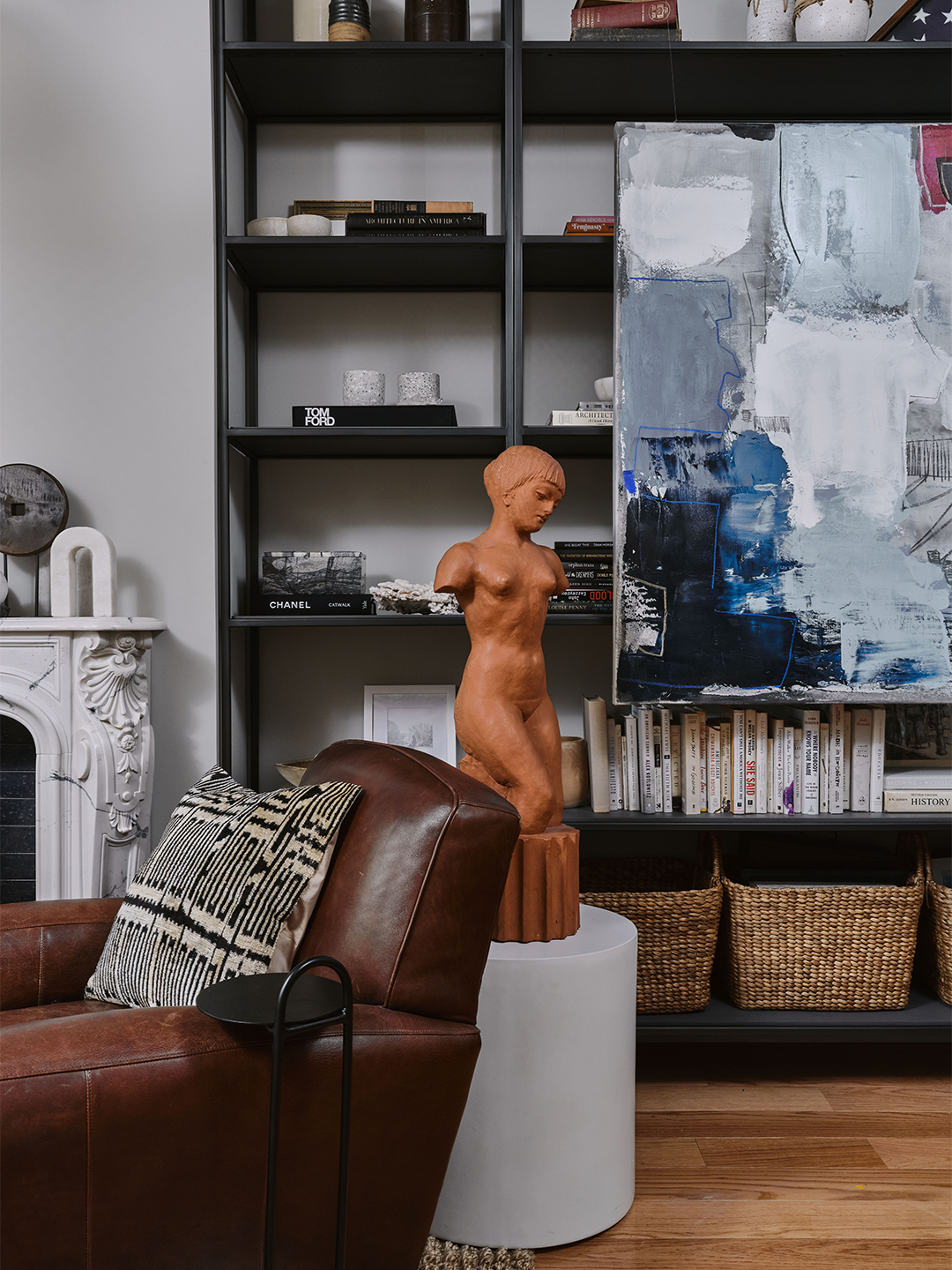 bookshelf with terra cotta sculpture in front