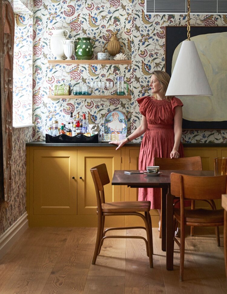 Rita Konig in a kitchen with mustard colored cabinets