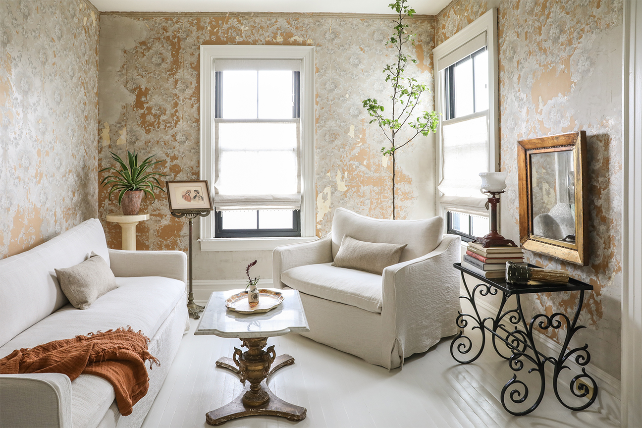 living room with antique plaster wallpaper, white furniture, antique table